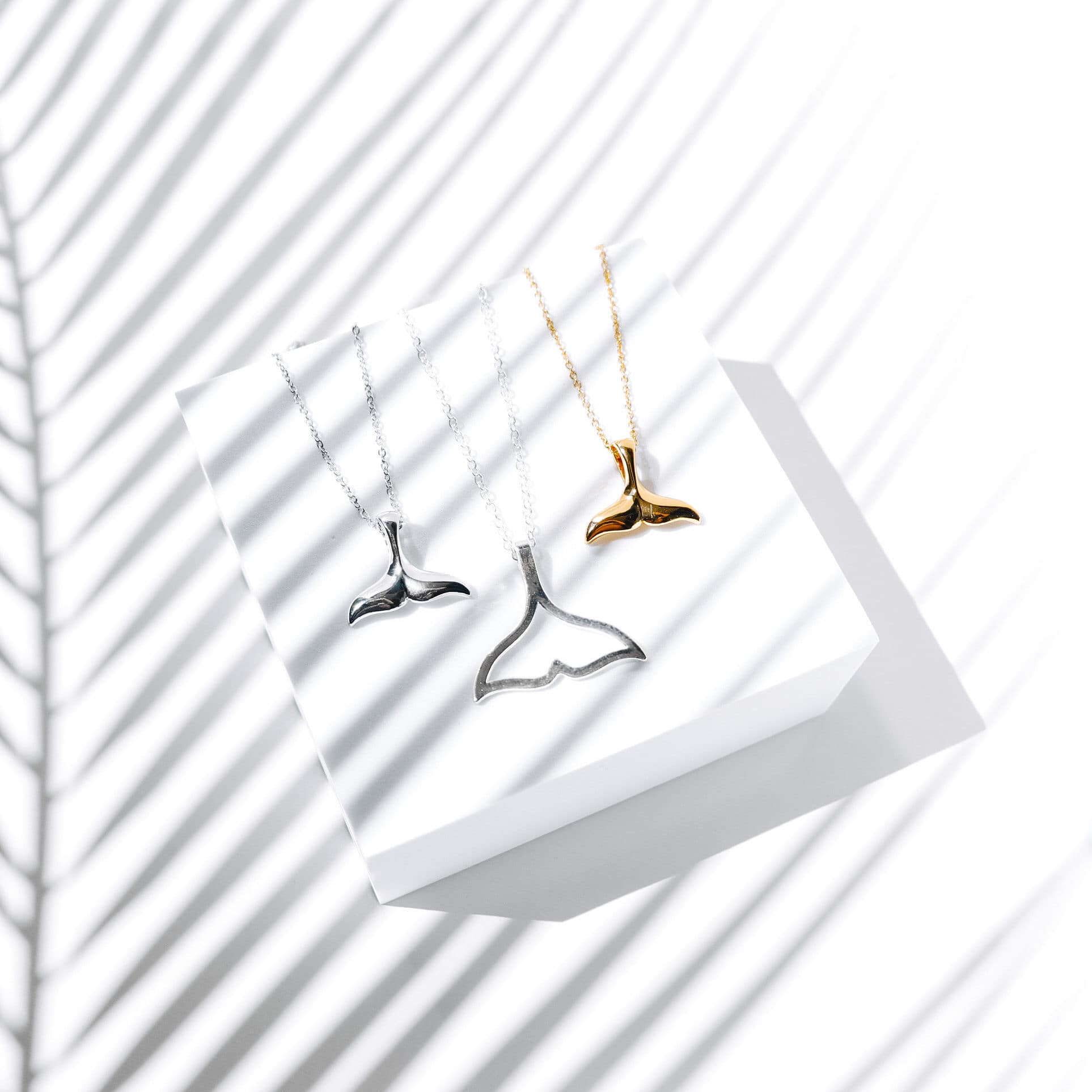 whale-tail-necklace-flat-lay-shadow